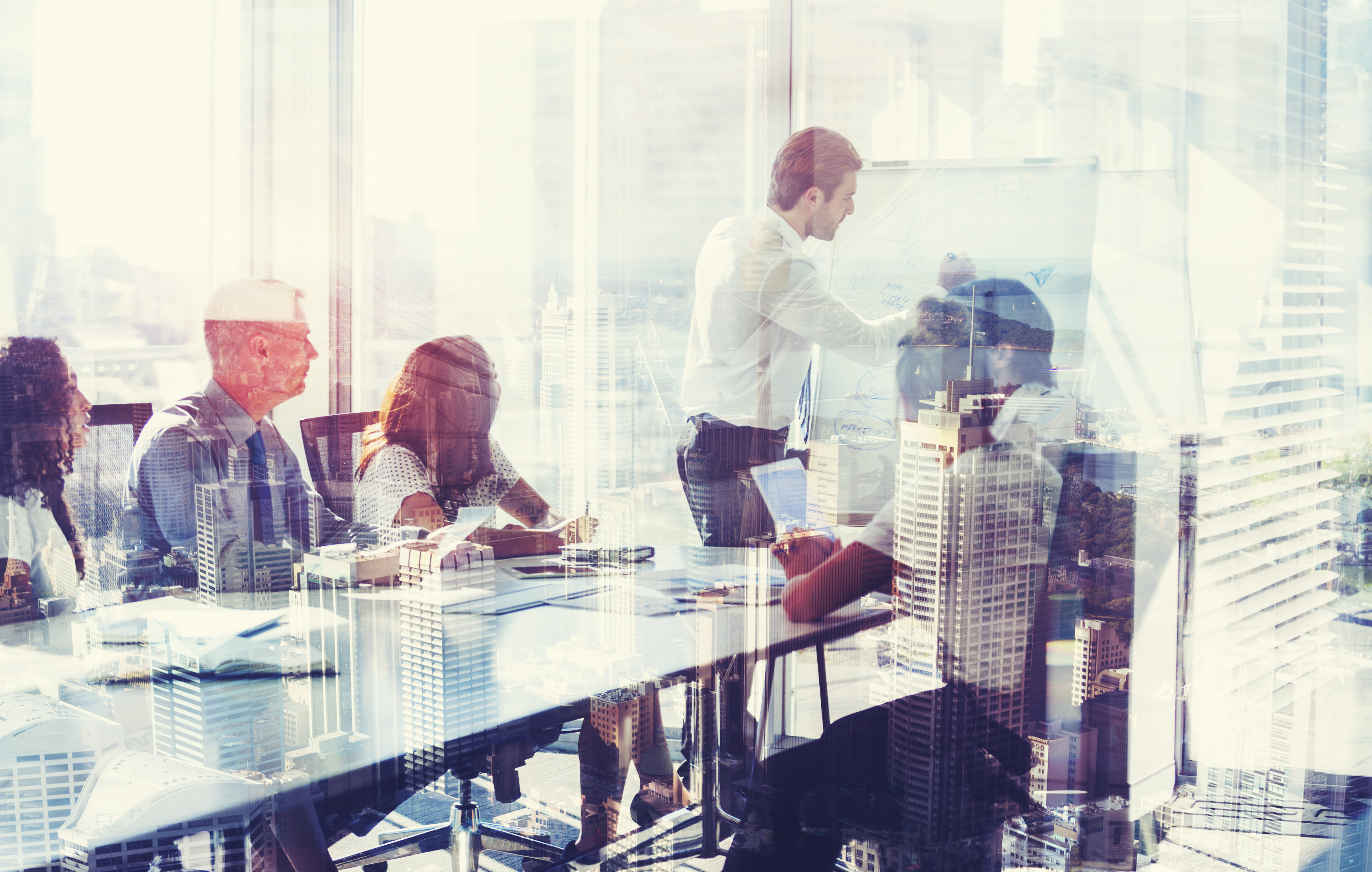 Montage of a team of business people at a presentation at the boardroom table. There are several buildings in an overlaid cityscape. There is also motion blurred traffic on a roadway in the middle of the group. City is Sydney, Australia. Business development; growth and architecture